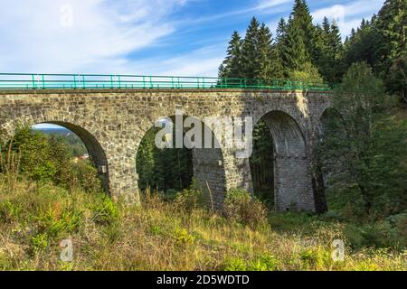 Vue sur le viaduc ferroviaire en pierre dans un petit village de Pernink, République tchèque. Ancienne ligne de chemin de fer tchèque. Pont d'arche vintage Banque D'Images