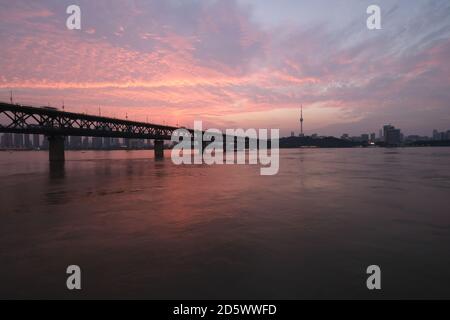 Coucher de soleil sur le pont du fleuve Yangtze de Wuhan. Point de repère de Wuhan, Hubei, Chine. Magnifiques nuages de coucher de soleil dans le ciel Banque D'Images