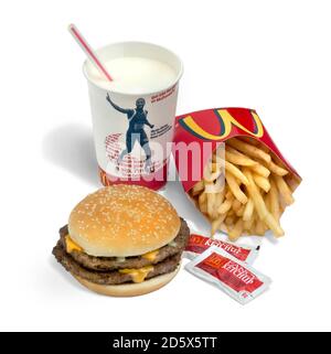 Repas McDonald's bon marché comprenant un double cheeseburger, milkshake à la vanille et des frites photographiées sur fond blanc Banque D'Images