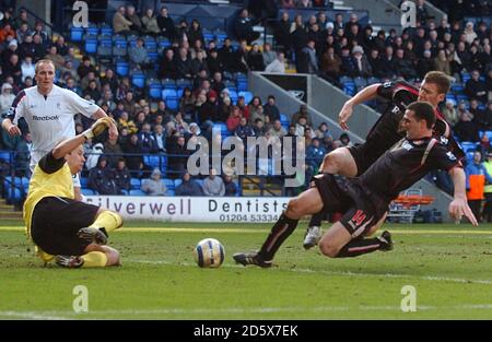 Tommy Miller et Kevin Kyle de Sunderland se sont glissent pour le Ball comme le gardien de but de Bolton Wanderers Jussi Jaaskelainen fait une économie Banque D'Images