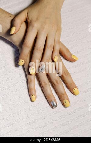 Par dessus une femelle anonyme montrant les mains avec des ongles peints sur serviette Banque D'Images