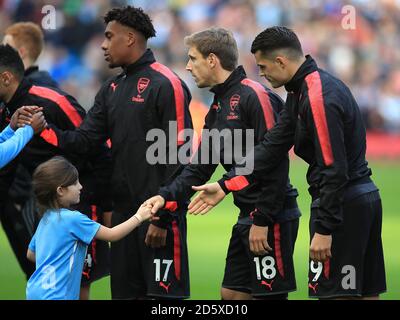 Une jeune mascotte de Manchester City serre les mains avec des joueurs d'Arsenal avant le jeu Banque D'Images