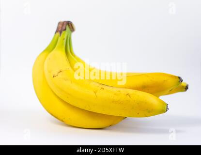 Bananes mûres jaunes.UN bouquet de bananes mûres avec des taches sombres sur un fond blanc. Banque D'Images