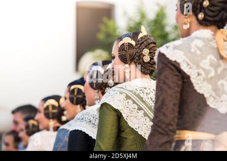 Un groupe de fallaeras dans une rangée vue de derrière. Robes avec nappe et style typique des fallas avec leurs bijoux. Photo horizontale. Banque D'Images