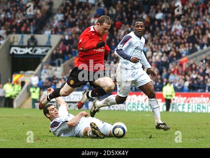 Wayne Rooney de Manchester United haies le défi de Bolton Wanderers Tal Ben Haim Banque D'Images