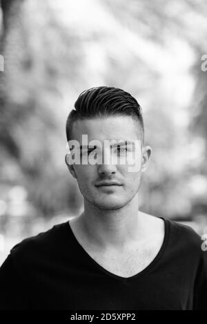 Young handsome man looking at camera, dans le stationnement Banque D'Images