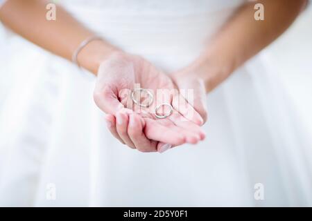 La femme de chambre des épouses tient des anneaux de mariage Banque D'Images