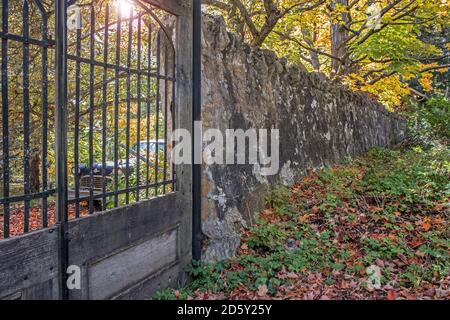 Pittoresque mur en pierre et porte à l'automne. Banque D'Images