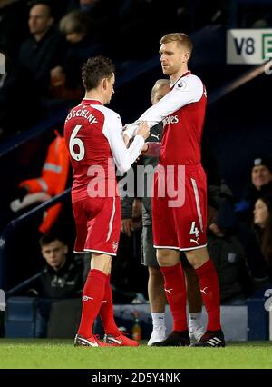 Le per Mertesacker d'Arsenal (à droite) est remplacé par le team-mate Arsenal Laurent Koscielny (à gauche) Banque D'Images