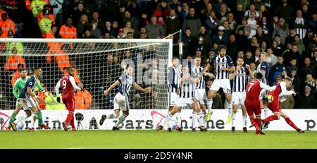 Alexis Sanchez d'Arsenal prend un coup de pied qui sort de l'Ouest James McClean de Bromwich Albion pour son propre but et son côté objectif d'ouverture Banque D'Images