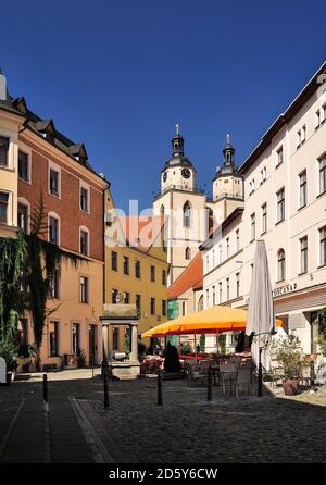 Allemagne, Lutherstadt Wittenberg, vue sur le café-terrasse, les maisons et l'église Sainte Marie en arrière-plan Banque D'Images