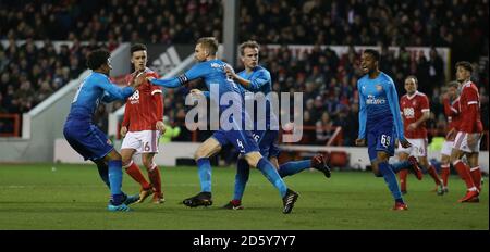 Arsenal's Per Mertesacker (au centre) célèbre le premier but de son côté du jeu Banque D'Images