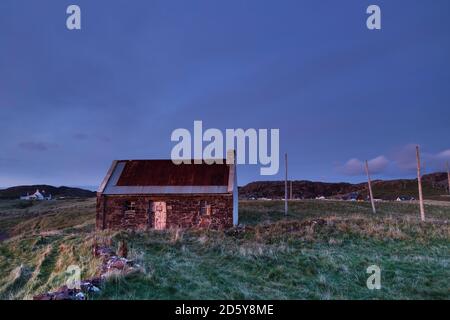 La pêche au saumon à péage de ClachToll Bothy avec filet desséchant Posts comme chutes de nuit au-dessus de ClachToll, Assynt, NW Highlands, Écosse, Royaume-Uni Banque D'Images