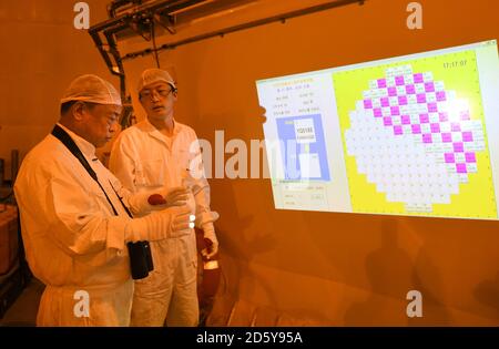 (201014) -- SHENZHEN, 14 octobre 2020 (Xinhua) -- Qiao Sukai (L) apprend l'état du remplacement des assemblages de combustible avec son membre de l'équipe à la centrale nucléaire Dayawan à Shenzhen, dans la province de Guangdong, dans le sud de la Chine, le 12 avril 2019. Tous les 18 mois, la centrale nucléaire de Dayawan doit subir un remplacement d'assemblages de combustible, qui est l'un des moments les plus importants pour la centrale nucléaire. Des dizaines d'ingénieurs sont répartis en quatre équipes et utilisent l'équipement de jour comme de nuit lorsque le réacteur est arrêté. Leur chef, Qiao Sukai, s'occupe du combustible nucléaire depuis le 1er juillet Banque D'Images