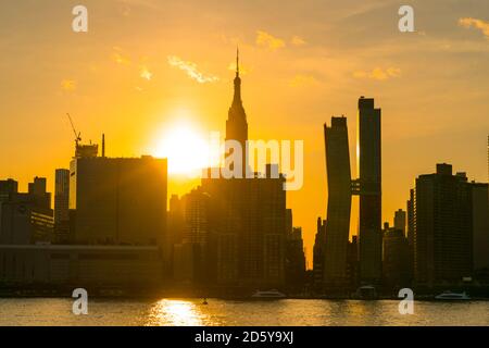 Le soleil se couche sur le gratte-ciel de Manhattan au-delà de l'East River.