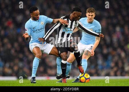 Christian Atsu (au centre) de Newcastle United lutte pour le bal avec Raheem Sterling de Manchester City (à gauche) et John Stones de Manchester City Banque D'Images