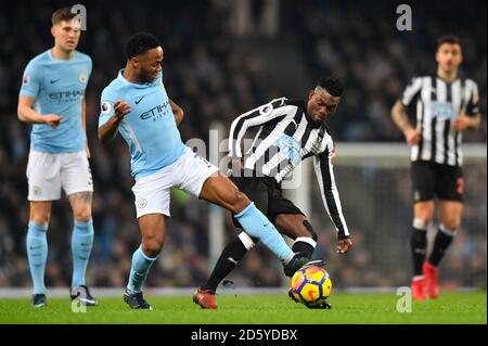 Christian Atsu (au centre) de Newcastle United lutte pour le bal avec Raheem Sterling de Manchester City Banque D'Images