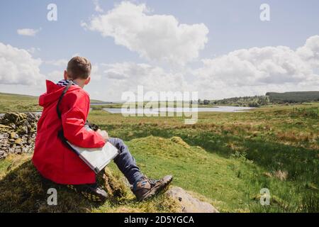 Garçon avec carte regardant la vue, Cairngorms, Ecosse, Royaume-Uni Banque D'Images