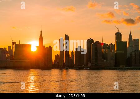 Le soleil se couche sur le gratte-ciel de Manhattan au-delà de l'East River.