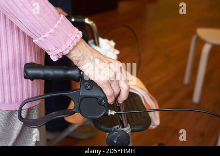 Démence d'âge senior woman with wheeled walker dans une maison de soins infirmiers Banque D'Images