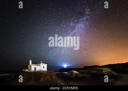 L'Espagne, la Galice, Valdovino, petite chapelle Virxe do Porto dans la côte galicienne dans une photo de nuit avec des étoiles et Milky Way Banque D'Images