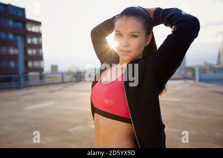 Portrait of young female Asian sportswoman doing stretching exercises Banque D'Images