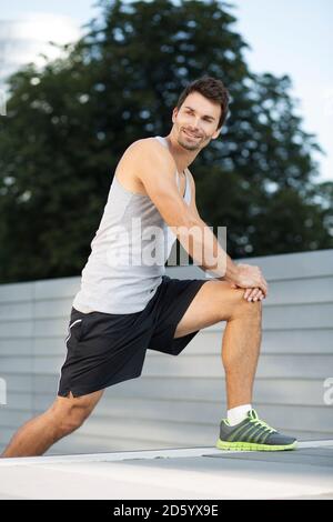 Sportsman faisant des exercices d'étirement sur un escalier Banque D'Images