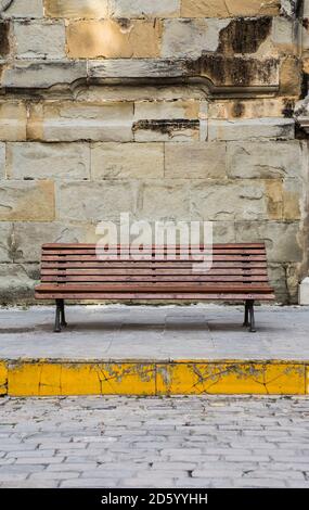 Espagne, Andalousie, Tarifa, banc en bois en face de mur de pierre Banque D'Images