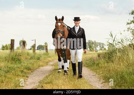 Rider menant son cheval sur un chemin de terre Banque D'Images