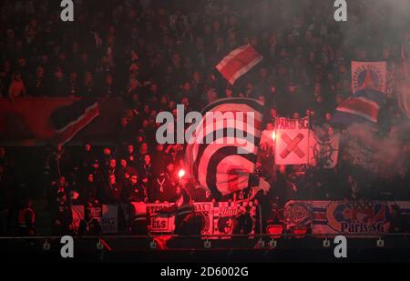 Les fans de Paris Saint-Germain dans les tribunes brandissent des drapeaux, des bannières et des fusées éclairantes pour montrer leur soutien pendant le match Banque D'Images