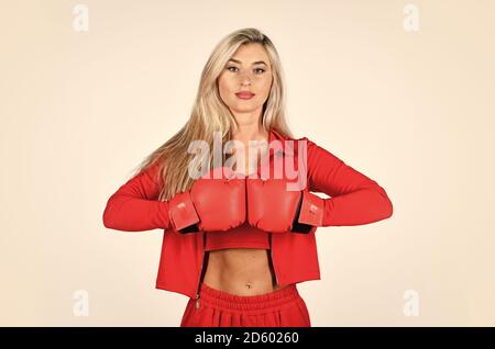 Auto-amélioration. Fille sportive rouge vêtements gants de boxe. Salle de gym et d'entraînement. Modèle de fitness. Style de vie sportif. Femme sportive entraîneur de fitness. Résoudre les problèmes. Formation personnelle. Lutte avec son propre complexe. Banque D'Images