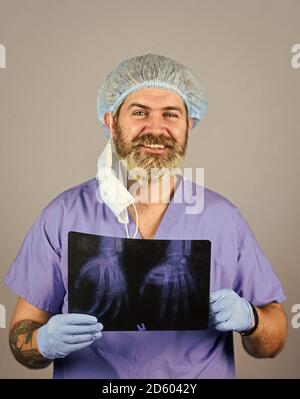 Le médecin possède des images d'os. Fracture et dommages osseux. Le médecin examine l'instantané radiographique du poignet. Le chirurgien estime les dommages. Urgence hospitalière. Le médecin compare les résultats. Rayonnement de rayons X. Banque D'Images