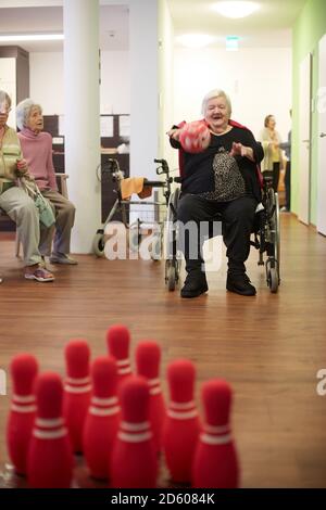 Démence d'âge senior woman bowling avec balle en mousse dans une maison de soins infirmiers Banque D'Images