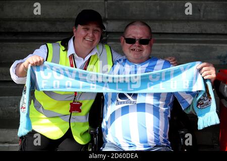 Un fan de Coventry City soutient son équipe dans les supports Banque D'Images