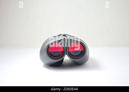 Binoculaire, jumelles avec lentilles rouges sur fond blanc style militaire avec vision nocturne pour usage domestique Banque D'Images