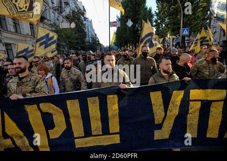 Kiev, Ukraine. 14 octobre 2020. Les vétérans de la guerre en cours contre les séparatistes soutenus par la Russie dans l'est de l'Ukraine marchent avec une énorme bannière pendant le rassemblement.les militants des mouvements nationalistes ukrainiens prennent part à un rassemblement marquant le 78e anniversaire de la création de l'Armée insurgente ukrainienne qui a lutté pour l'indépendance contre l'Armée rouge soviétique Et les Nazis pendant la deuxième Guerre mondiale L'Ukraine célèbre le défenseur de la Journée de la Patrie. Crédit : SOPA Images Limited/Alamy Live News Banque D'Images