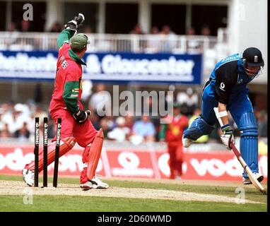 Le Marcus Trescothick (r) d'Angleterre vient juste de faire son terrain comme Andy Flower (l), le gardien de cricket du Zimbabwe, reconnaît le retour à la course lui Banque D'Images