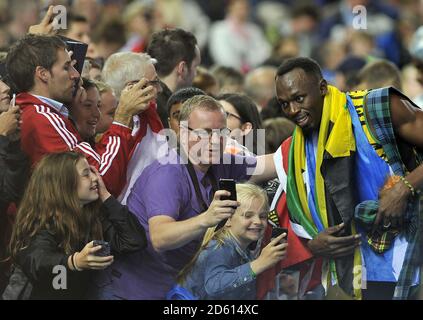 Photo du fichier : Usain Bolt essaie pour l'équipe de football australienne Central Coast Mariners. La Jamaïque Usain Bolt porte tartan comme il pose avec les fans après avoir gagné le relais hommes 4x100m ... Sport - Jeux du Commonwealth 2014 - jour dix ... 02-08-2014 ... Glasgow - Hampden Park ... Royaume-Uni ... Le crédit photo devrait se lire comme suit : EMPICS Sport/EMPICS Sport. Référence unique n° 20559041 ... Banque D'Images