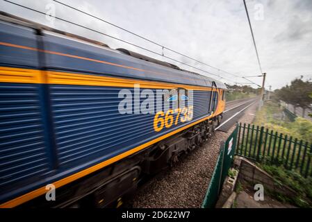 GB Railfreight classe 66 locomotive 66735 nommé Peterborough United, train de dégagement de rail de conduite pulvérisant les rails propres pour améliorer la traction Banque D'Images