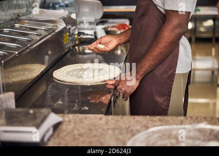 Afro-américain cuisant de la pizza au restaurant Banque D'Images