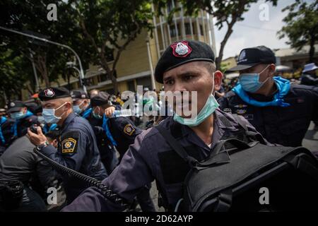 Bangkok, Thaïlande. 14 octobre 2020. La police thaïlandaise a tenté de repousser les manifestants pro-démocratie après que des affrontements aient éclaté avec des partisans ultra royalistes lors d'une manifestation anti-gouvernementale. Des milliers de manifestants pro-démocratie ont pris les rues, du Monument de la démocratie jusqu'à la Maison du Gouvernement qui a demandé la démission du Premier ministre thaïlandais, Prayut Chan-o-cha, à l'occasion du 47e anniversaire de la révolution du soulèvement étudiant de 1973 qui a renversé le gouvernement soutenu par l'armée. Crédit : SOPA Images Limited/Alamy Live News Banque D'Images