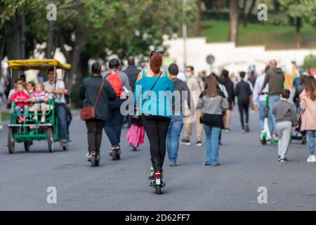 Rome, Italie - 10 octobre 2020 : une femme voyage dans la ville à bord d'un scooter électrique loué. Banque D'Images