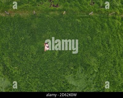 Femme méditant dans un champ d'herbe vide.