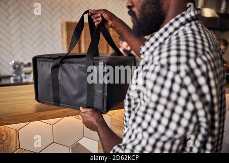 Jeune homme afro-américain saisissant le sac de livraison de nourriture Banque D'Images