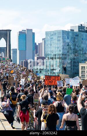 Foule de manifestants avec des panneaux traversant le pont de Brooklyn au cours du dix-septième mars, New York, New York, États-Unis Banque D'Images