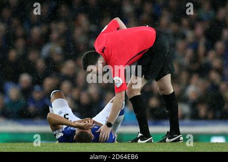 L'arbitre Chris Kavanagh vérifie l'état d'Everton Richarlison après qu'il a pris une blessure Banque D'Images