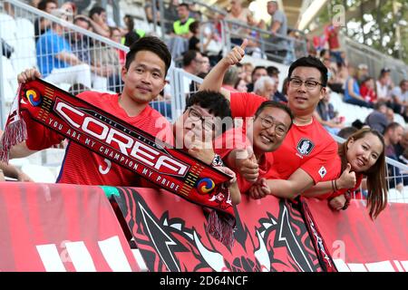 Les fans sud-coréens posent avec un foulard sud-coréen devant eux de la correspondance Banque D'Images