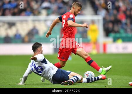 Le Michael Jacobs de Wigan Athletic est abordé par Andrew Hughes de Preston North End Banque D'Images