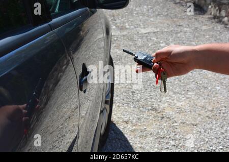Personne utilisant une clé de voiture sans fil à distance pour déverrouiller ou verrouiller un véhicule, Banque D'Images