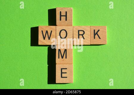 Maison, travail, mots en lettres de l'alphabet en bois en forme de mots croisés isolés sur fond vert Banque D'Images